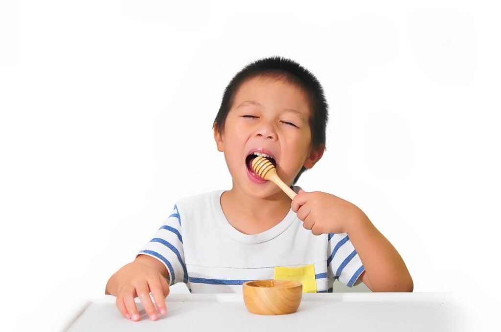 男の子がはちみつをおいしそうに食べている