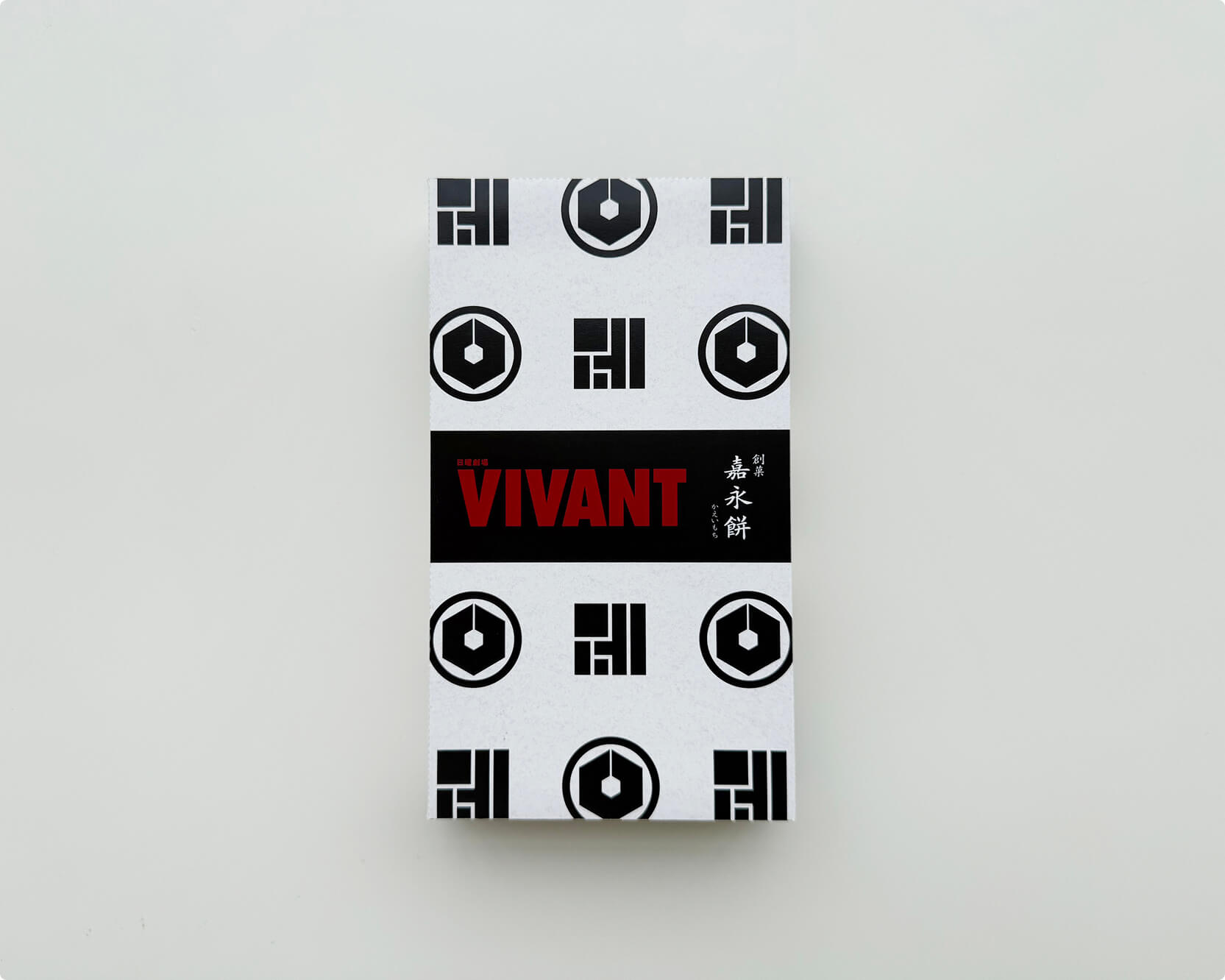 VIVANTのお菓子の黒い帯に赤いVIVANTの文字と「創菓 嘉永餅」の文字が入った白い包み。上下に黒い印が並ぶ