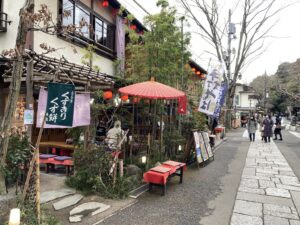VIVANTの石畳の道沿いの店先に置かれた赤い傘と赤い縁台
