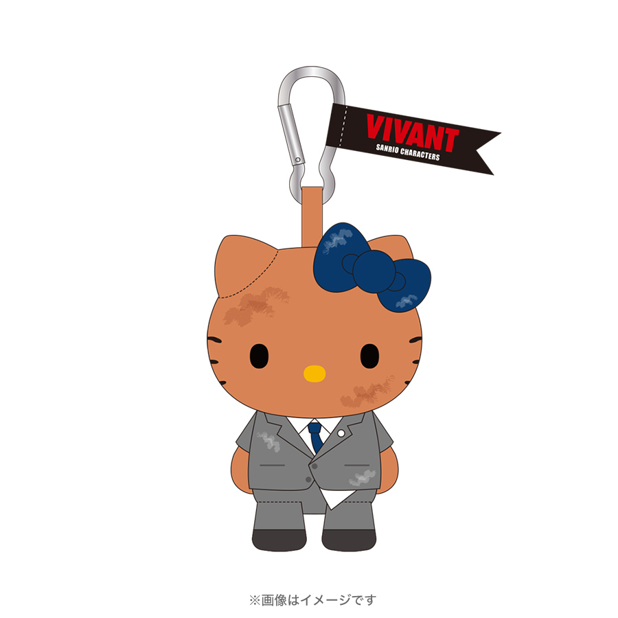 VIVANTとサンリオのグレーのスーツに青いネクタイを締めたハローキティのむにゅぐるみと、カラビナに付いた「VIVANT」の旗