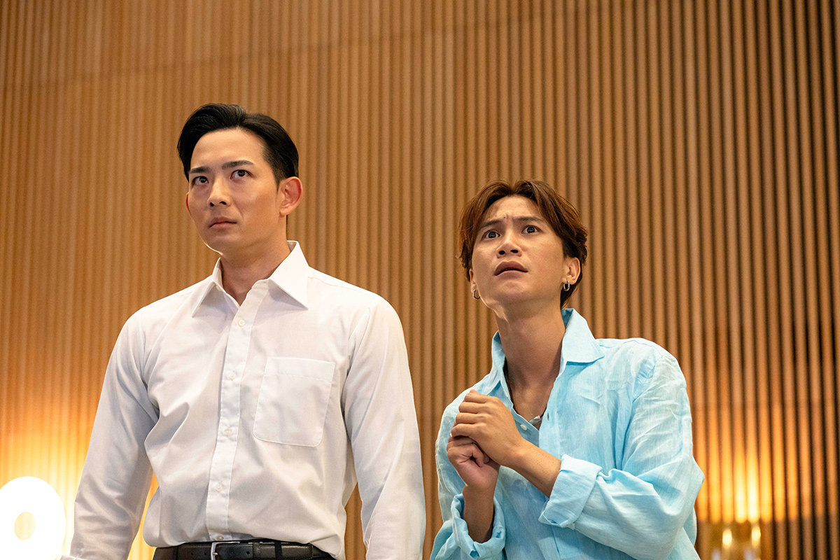 新庄の第13話の場面写真。白いシャツの男性と水色のシャツの男性が並んで、上を見上げている