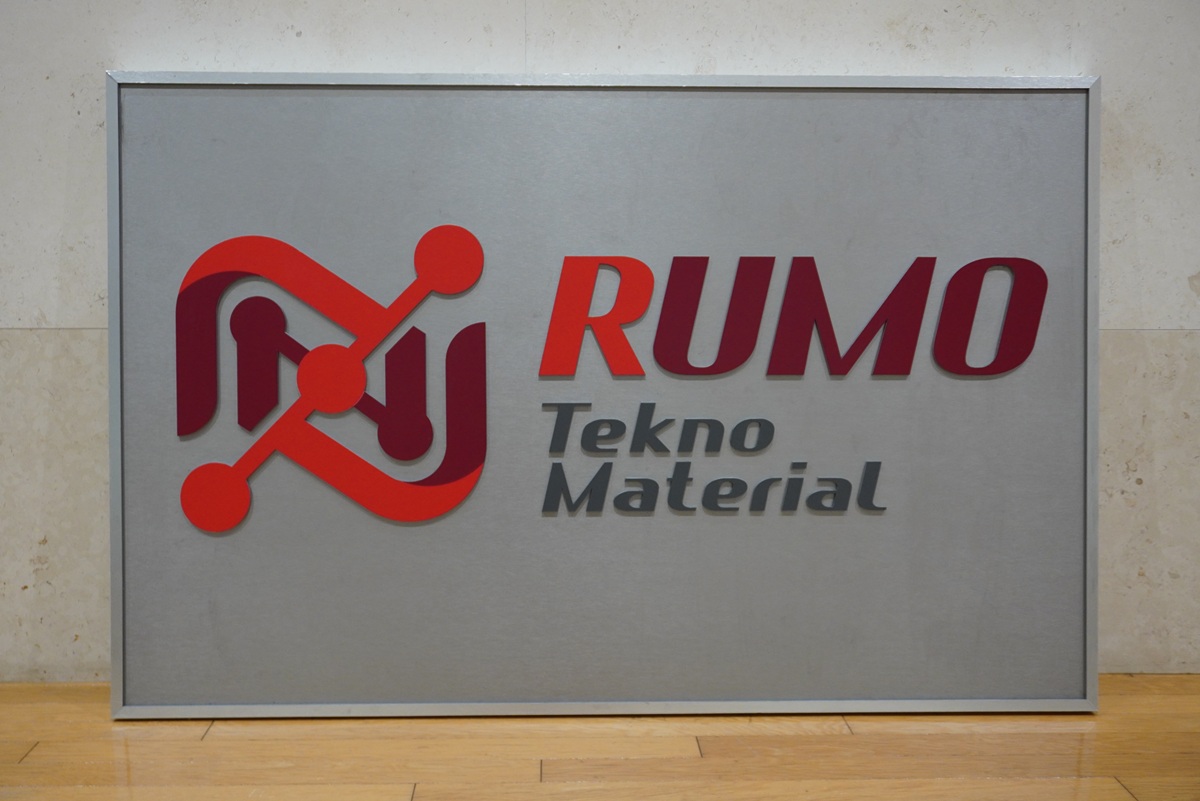 セラミックパークMINOの灰色の板に赤い字でRUMO、その下にTekno Materialと書かれた看板