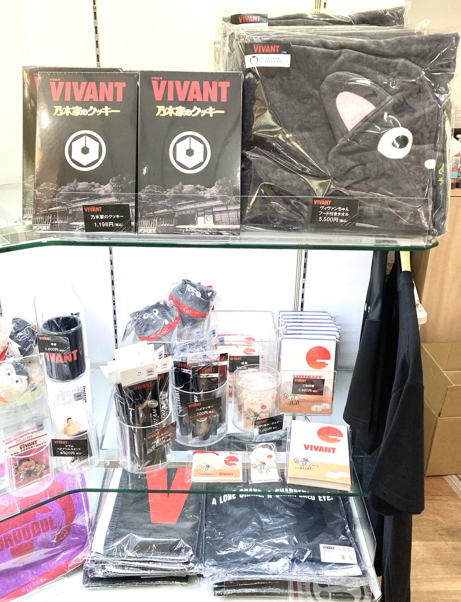 VIVANTのグッズの棚に並ぶ「乃木家のクッキー」の黒い箱と、ヴィヴァンちゃん フード付きタオル